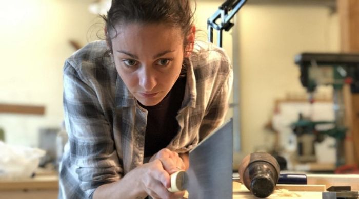 A woodworking student using a Japanese saw