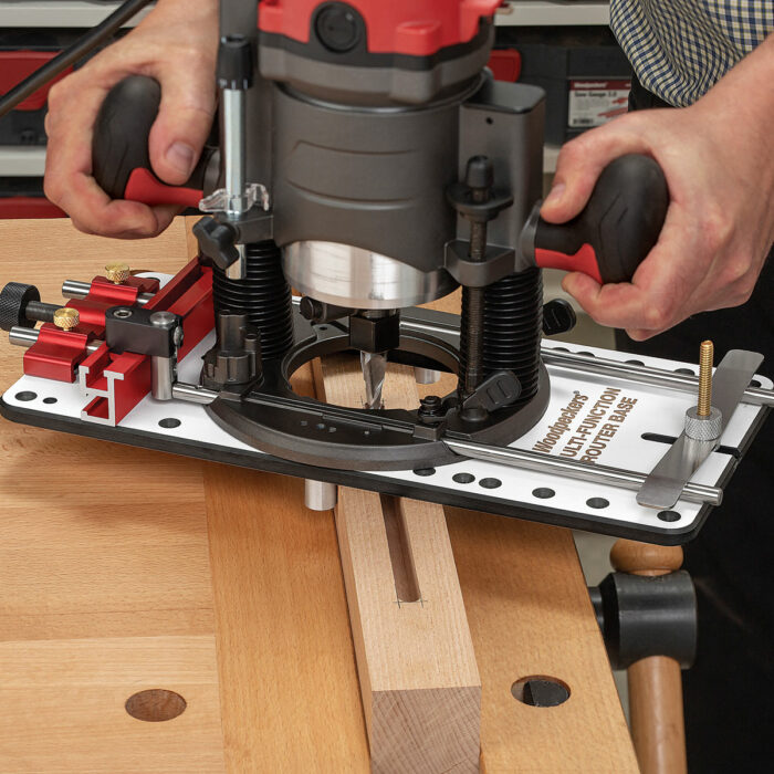 Mortising too. Two large pins inserted under the plate center it for mortising. To cut off-center mortises, you clamp a strip of wood next to your workpiece.